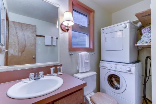 a bathroom with a sink and a washing machine at The Little Brown House MCA #705 in Manzanita
