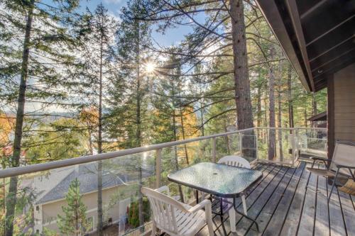 a deck with a table and chairs and trees at Bay Point Hillside 17A Up in Whitefish
