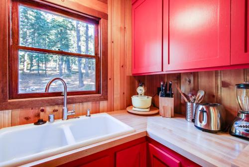 eine Küche mit roten Schränken, einem Waschbecken und einem Fenster in der Unterkunft The Cherry Leaf Lodge & Retreat on Fallen Leaf Lake in Fallen Leaf