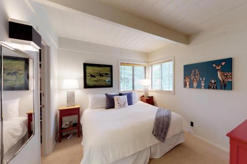 a white bedroom with a bed and two windows at Tranquil Family Retreat in Sun Valley