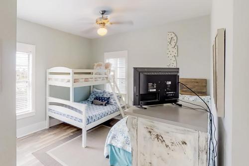 a white room with a bunk bed and a desk at Barefoot Cottages #B10 in Highland View
