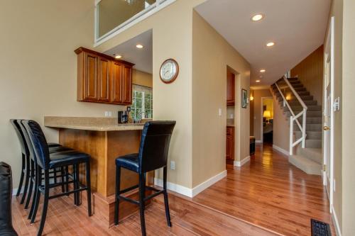 a kitchen with a bar with black stools at Lake House PlayLand in Lincoln City
