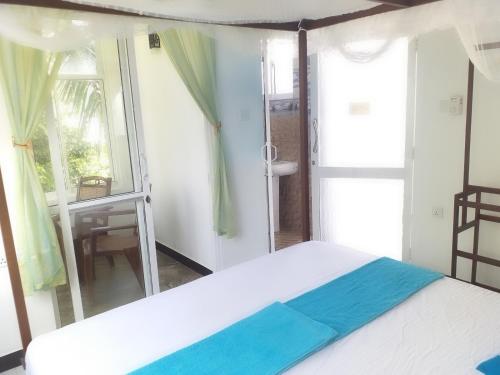 a bedroom with a white bed and a window at Rai Family Guest in Matara