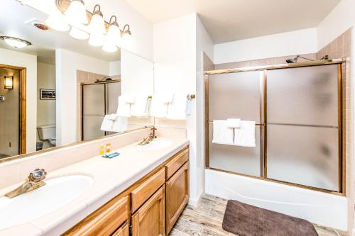 W łazience znajduje się umywalka i prysznic. w obiekcie Paw's Cabin w mieście Shaver Lake