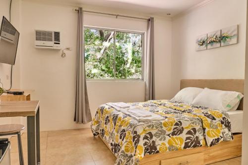 Schlafzimmer mit einem Bett und einem Fenster in der Unterkunft Hidden Hill Hotel in Mactan
