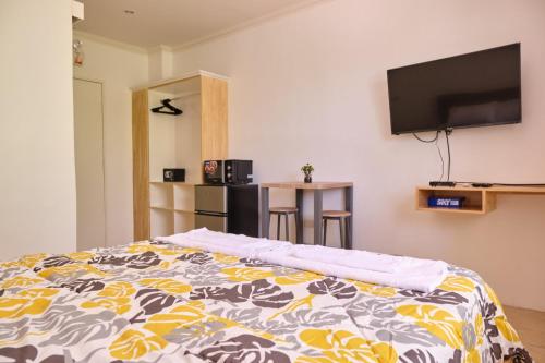 a bedroom with a bed and a flat screen tv at Hidden Hill Hotel in Mactan