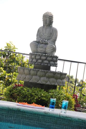 a statue sitting next to a swimming pool with a statue at Tu cabaña Cuernavaca - hospedaje by Arcadia in Cuernavaca