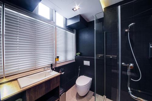 a bathroom with a toilet and a sink and a shower at CUBE Boutique Capsule Hotel at Chinatown in Singapore