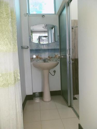 a bathroom with a sink and a glass shower at Rai Family Guest in Matara