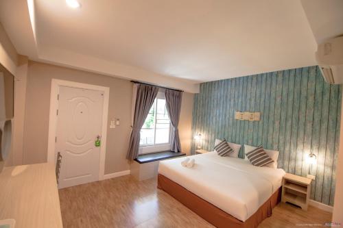 a hotel room with a bed and a window at Color Ville Hotel SHA Certified in Sakon Nakhon