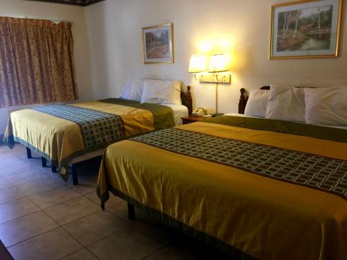 a hotel room with two beds in a room at Texas Inn and Suites RGV in Edinburg