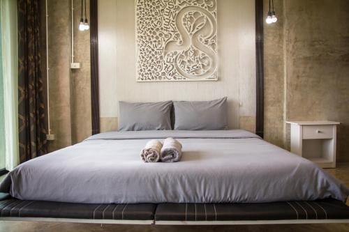a bedroom with a bed with two towels on it at Phu Pha View Doi in Samoeng
