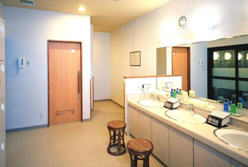 a bathroom with two sinks and two stools at Hotel Route-Inn Mooka in Mooka