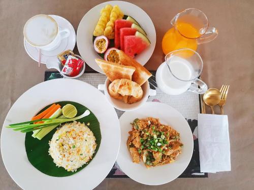 a table topped with plates of food and drinks at Lanna Deer Resort Chiang Mai in Chiang Mai