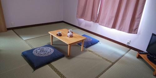 a room with a table and two chairs and a television at Guest House Fuku-chan in Kaiyo