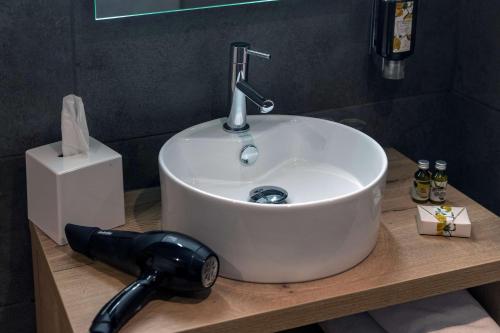 a white sink on a counter in a bathroom at Hotel KLE, BW Signature Collection in Kaysersberg
