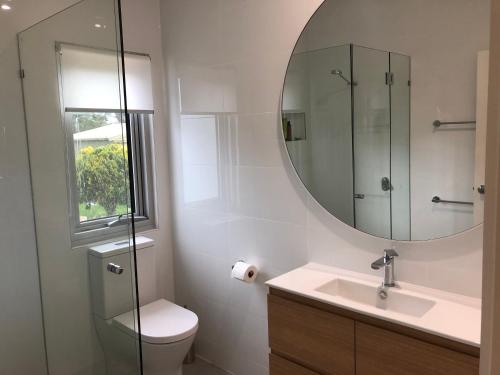 a bathroom with a toilet and a sink and a mirror at WHITE SHELLS HOLIDAY RENTAL in Nepean Bay