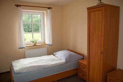 ein kleines Schlafzimmer mit einem Bett und einem Fenster in der Unterkunft Penzion Javorský mlýn in Lázně Bělohrad