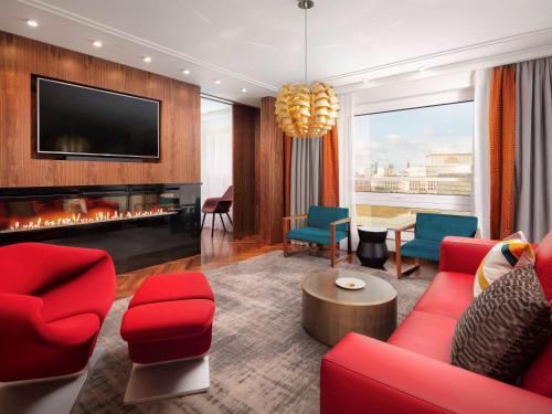 a living room with red furniture and a fireplace at Sofitel Warsaw Victoria in Warsaw