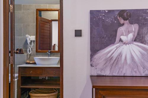 a bathroom with a painting of a woman in a wedding dress at Lanna Deer Resort Chiang Mai in Chiang Mai