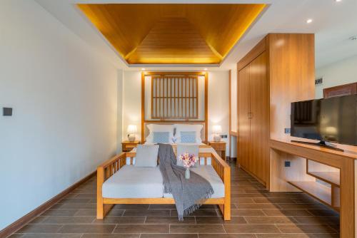 a living room with a couch and a tv at Lanna Deer Resort Chiang Mai in Chiang Mai
