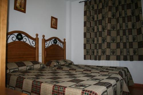 a bedroom with a bed with a checkered blanket at Apartamentos Mirasierra in Coto Ríos