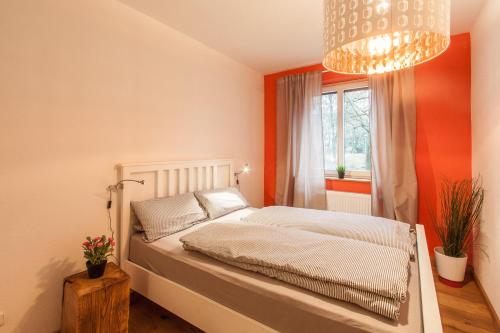 Schlafzimmer mit einem Bett, einem Fenster und einem Kronleuchter in der Unterkunft Ringpark-Ferien in Würzburg