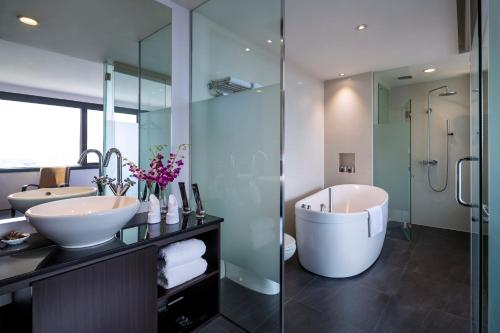 a bathroom with two sinks and a tub and a shower at Furama City Centre in Singapore