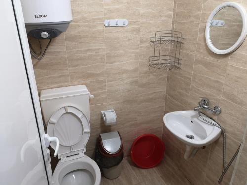 a small bathroom with a toilet and a sink at Bungalows St. Nicola in Ahtopol