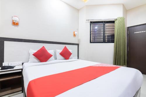 a bedroom with a red and white bed and a desk at Hotel Bestend in Bengaluru
