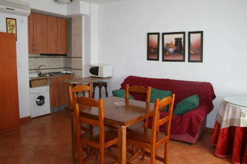 cocina y comedor con mesa y sofá en Apartamentos Mirasierra, en Coto Ríos