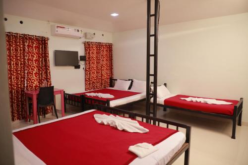 a room with two bunk beds and a tv at PAVITHRAM RESIDENCY in Kollam