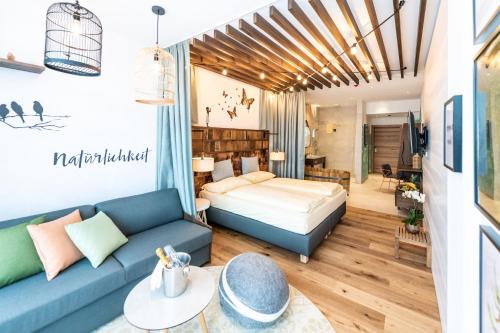 a living room with a bed and a couch at Hotel Vier Jahreszeiten Loipersdorf in Loipersdorf bei Fürstenfeld