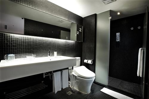 a bathroom with a sink and a toilet and a mirror at Just Sleep - Ximending in Taipei