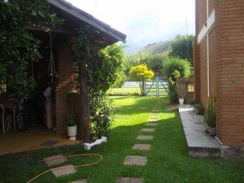 a cat laying on the grass next to a house at Pousada Nasa in São Bento do Sapucaí