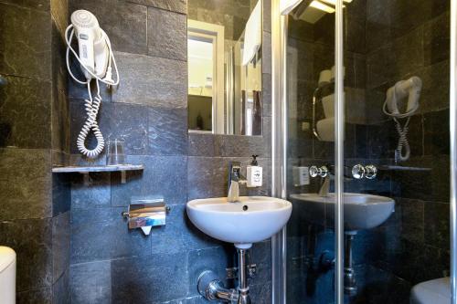 a bathroom with a sink, toilet and mirror at Rex Hotel in Stockholm