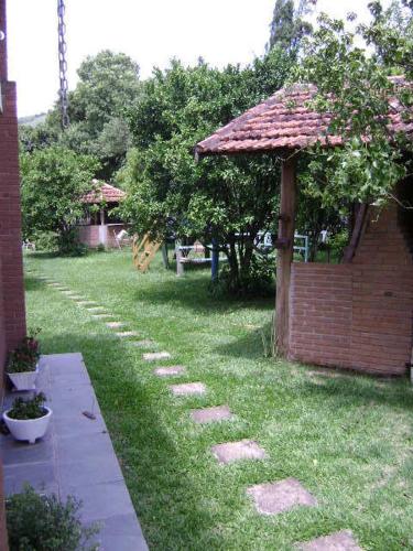 a garden with a brick building and a grass yard at Pousada Nasa in São Bento do Sapucaí