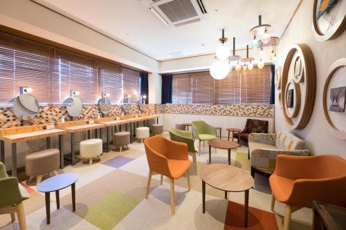 a waiting room with colorful chairs and tables at Matsue Urban Hotel CubicRoom in Matsue
