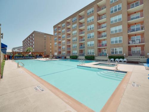 a large swimming pool in front of a building at Relaxing Condo, Great Location, 3 Minute Walk To The Beach Condo in South Padre Island