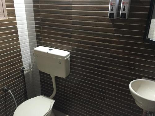 a bathroom with a toilet and a sink at Dream Vision Guest House in Diu