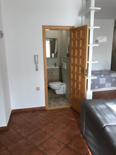 een badkamer met een toilet en een deur naar een slaapkamer bij Apartamento amplio y tranquilo con vistas in Los Realejos