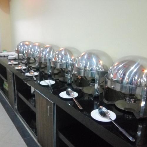 a row of pots and pans sitting on a counter at Hotel Crown Inn Multan in Multan