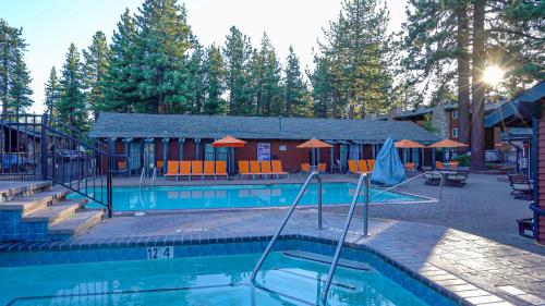 a swimming pool with a pool table and chairs at 3 Peaks Resort & Beach Club in South Lake Tahoe