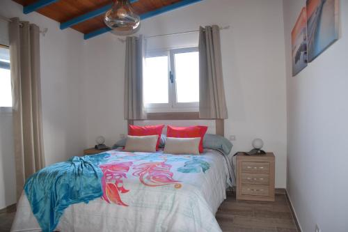 プエルト・デ・モガンにあるCasa Nicolas y Pinoのベッドルーム1室(大型ベッド1台、赤い枕付)