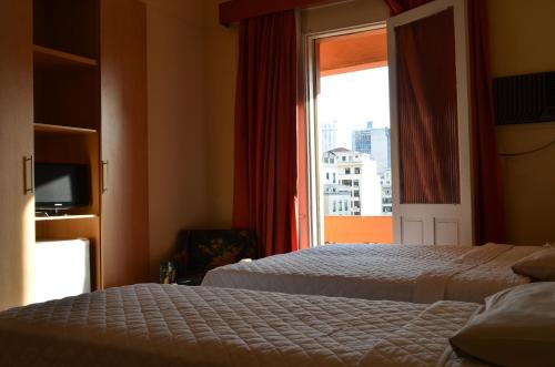 a hotel room with two beds and a window at Lux Hotel in Sao Paulo