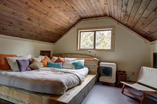 1 dormitorio con 1 cama grande y techo de madera en Flying Stag: Upper Chalet, en Government Camp