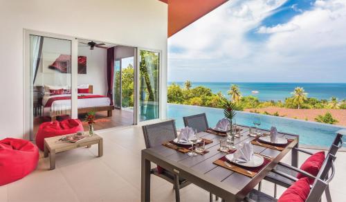 ein Esszimmer mit einem Tisch und Meerblick in der Unterkunft Eranda Pool Spa Villa, Chaweng Koh Samui- SHA Extra Plus in Chaweng