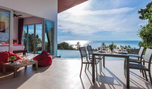 a dining room with a view of the ocean at Eranda Pool Spa Villa, Chaweng Koh Samui in Chaweng