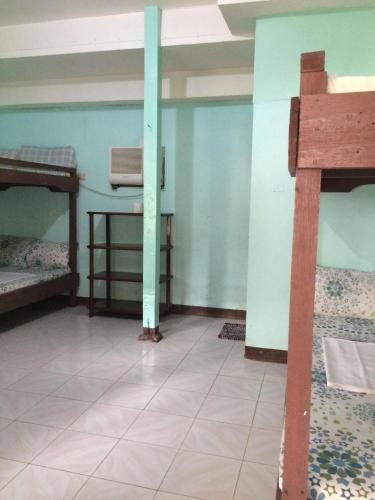 a room with two bunk beds and a tile floor at Oasis Resthouse in San Agustin