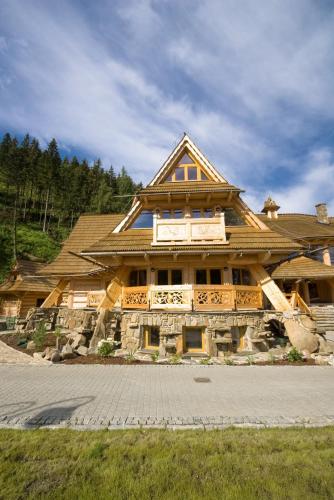 a large wooden house with a gambrel roof at Ośrodek Wypoczynkowy Marymont przy Dolinie Kościeliskiej in Kościelisko